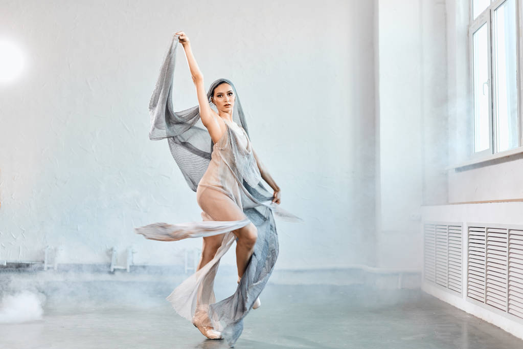 白い流れる生地を持つ女性バレエダンサー。流れの形と動き. - 写真・画像