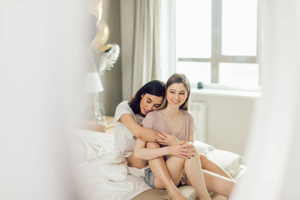 молодые красивые девушки с позитивным настроением проводят время в постели
 - Фото, изображение