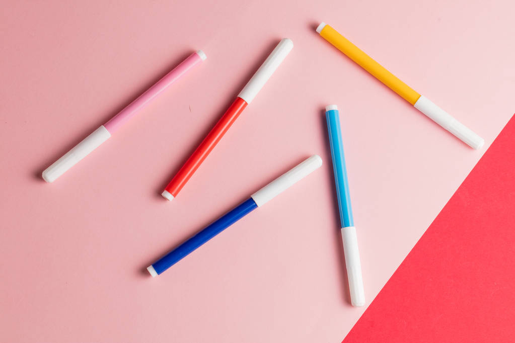 quatro canetas de feltro isoladas sobre fundo rosa e vermelho
 - Foto, Imagem