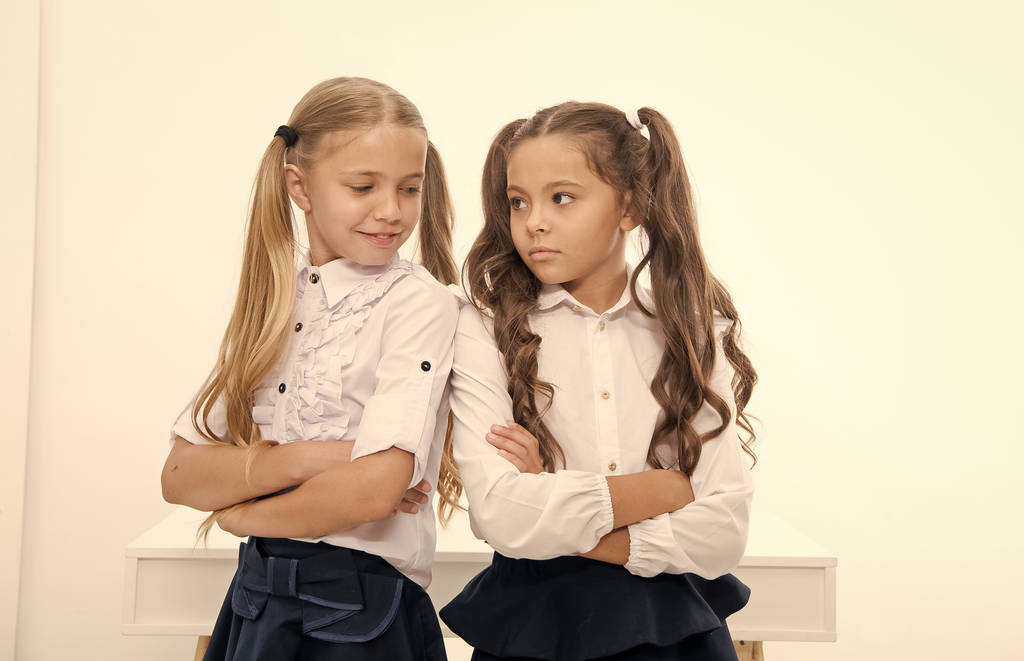 Les petites filles en uniforme scolaire croisent les bras. Tu retournes à l'école et tu as l'air en uniforme. petites filles
. - Photo, image