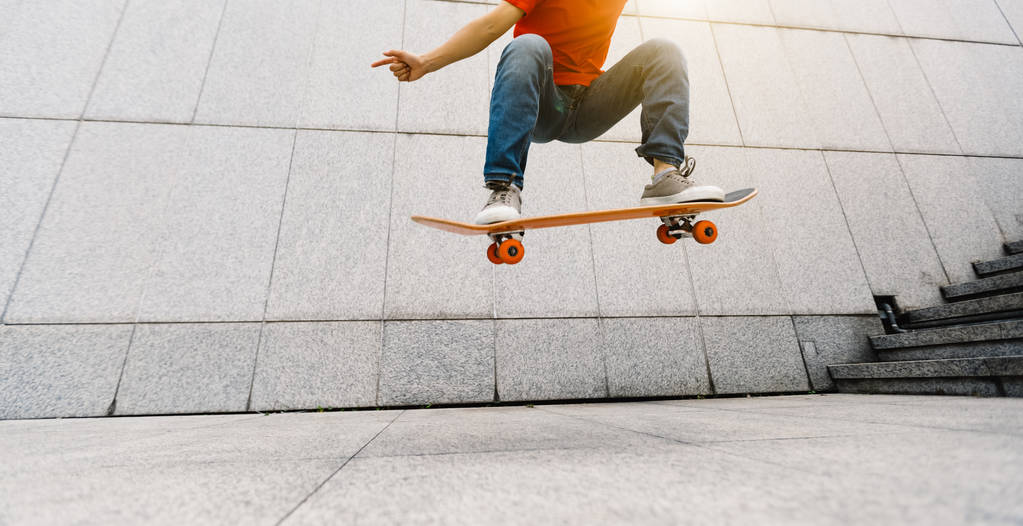 Молодой скейтбордист делает Олли в городе
   - Фото, изображение