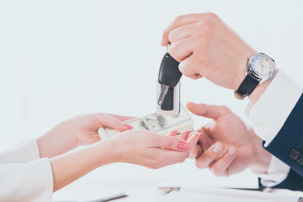 обрізаний вид бізнесмена, що тримає ключі від автомобіля і бере гроші від клієнта
 - Фото, зображення