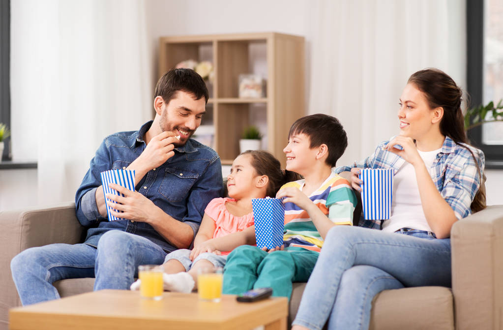 onnellinen perhe popcorn katsella televisiota kotona
 - Valokuva, kuva