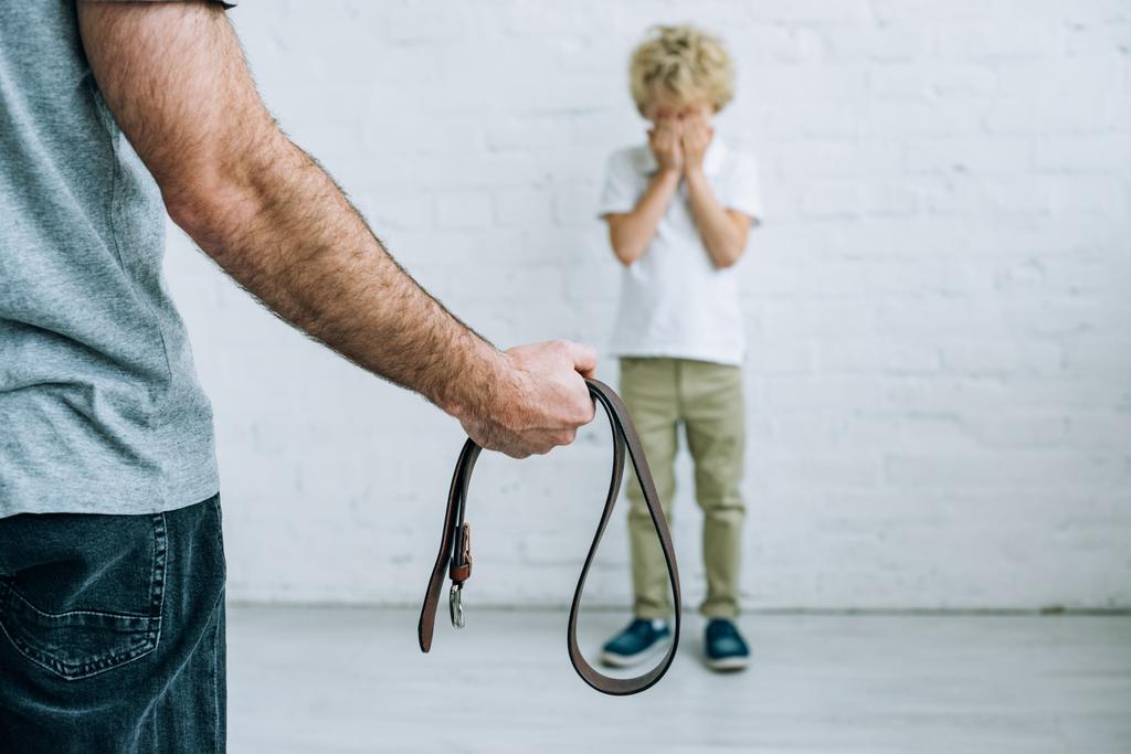 kemer ve evde ağlayan oğlu ile baba kırpılmış görünümü - Fotoğraf, Görsel