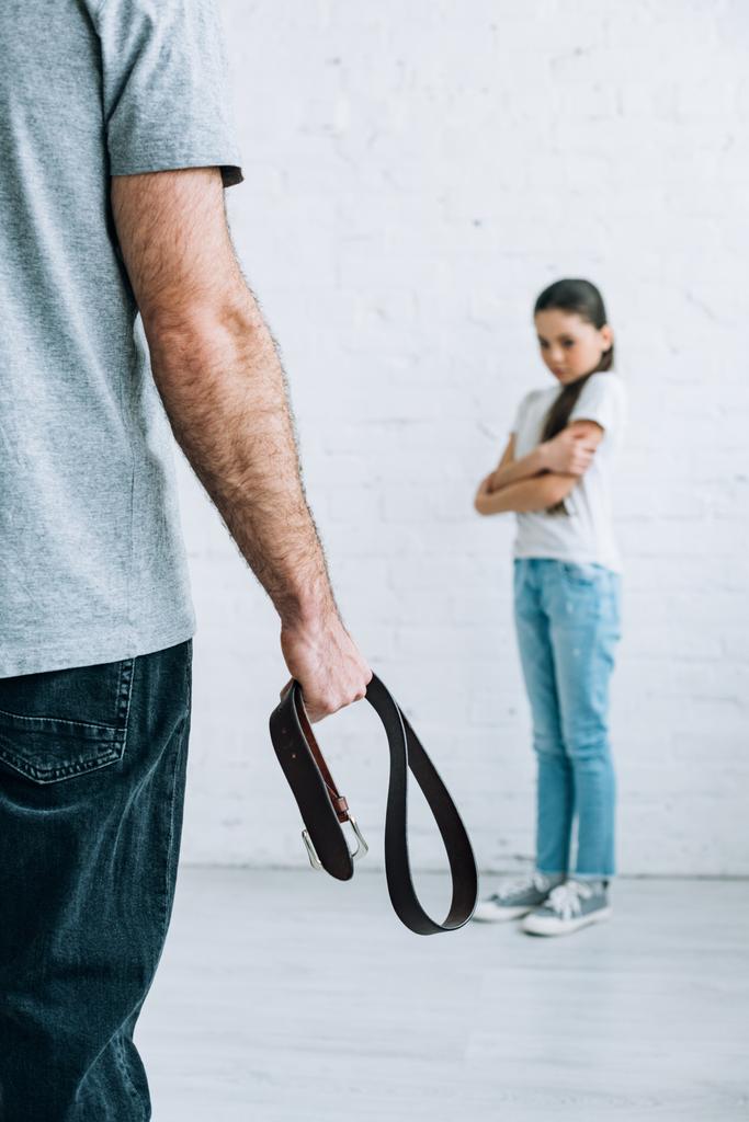 vista recortada del cinturón de sujeción del padre y la hija molesta en casa
 - Foto, imagen