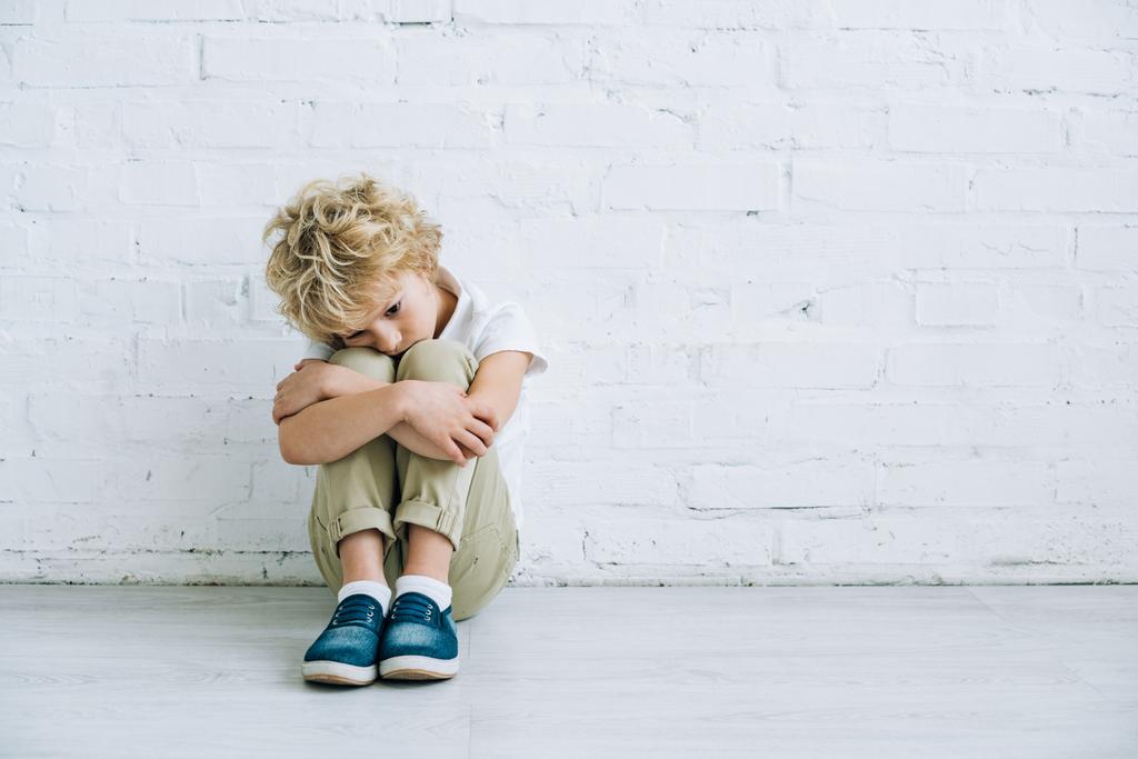 bouleversé préadolescent garçon assis sur le sol à la maison
 - Photo, image