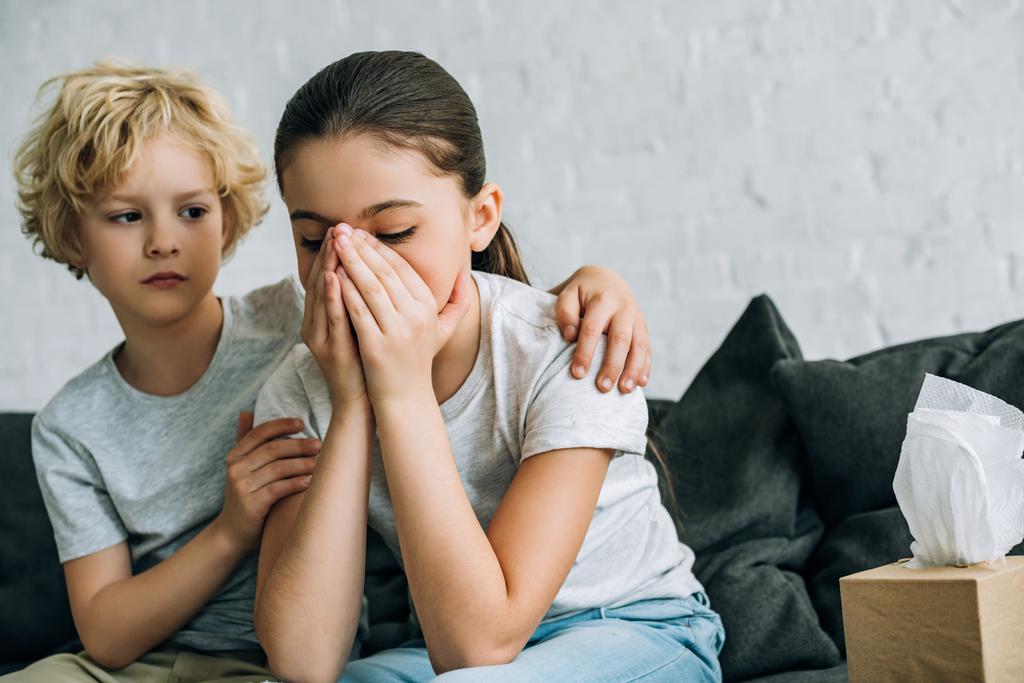 little brother consoling crying sister in living room - Photo, Image