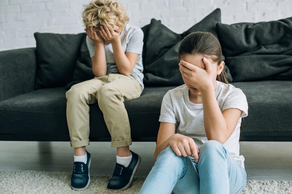 двое грустных дошкольников плачут в гостиной
 - Фото, изображение
