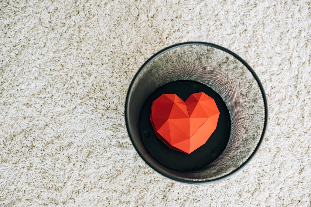 червоне серце в чорному смітті на килимі
 - Фото, зображення