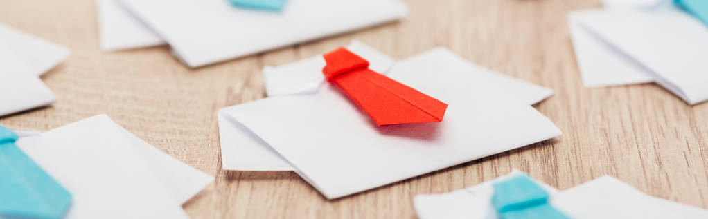 panoramatický záběr z origami bílých triček s modrými vazbami s jednou červenou na dřevěné ploše - Fotografie, Obrázek