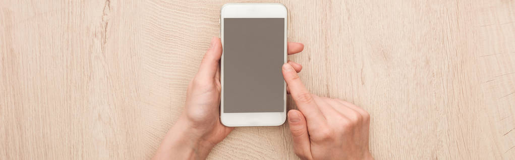 panoramic shot of woman holding smartphone with blank screen - Photo, Image