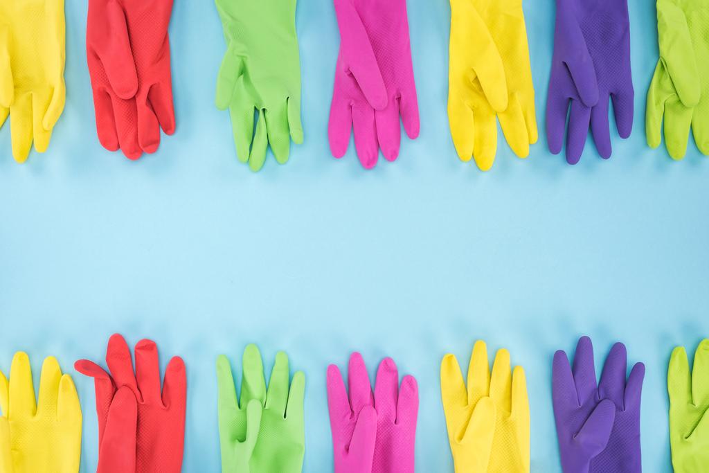 top view of multicolored bright rubber gloves on blue background with copy space - Photo, Image