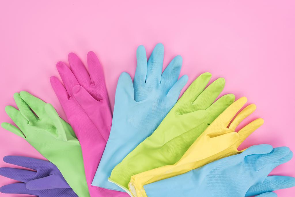 vista superior de guantes de goma multicolores sobre fondo rosa
 - Foto, imagen