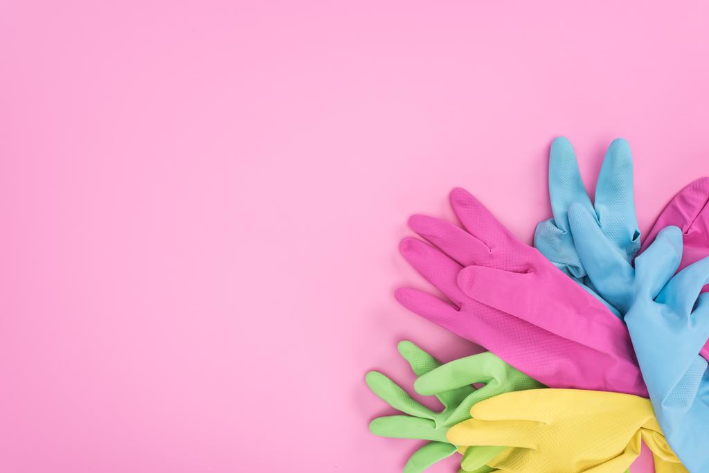 horní pohled na vícebarevné gumové rukavice na růžovém pozadí s prostorem pro kopírování - Fotografie, Obrázek