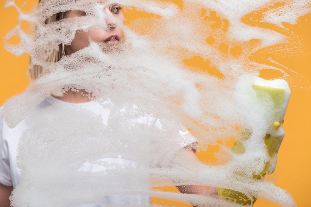 jovem mulher em luva de borracha com esponja de limpeza de vidro coberto com espuma no fundo laranja
 - Foto, Imagem