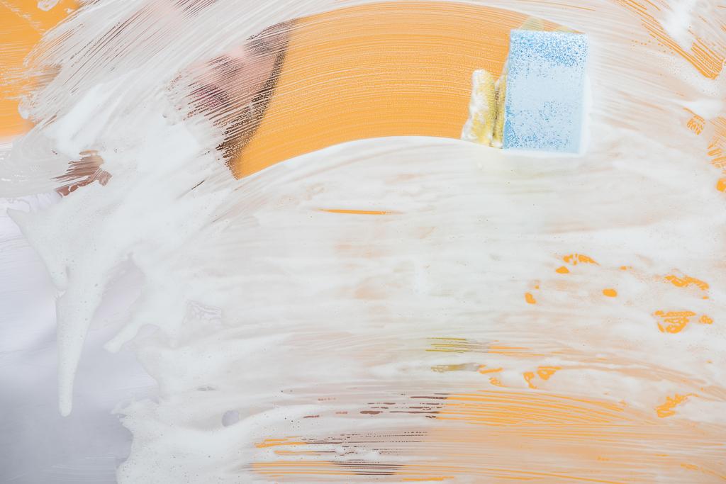 jovem mulher em luva de borracha com esponja de limpeza de vidro coberto com espuma
  - Foto, Imagem