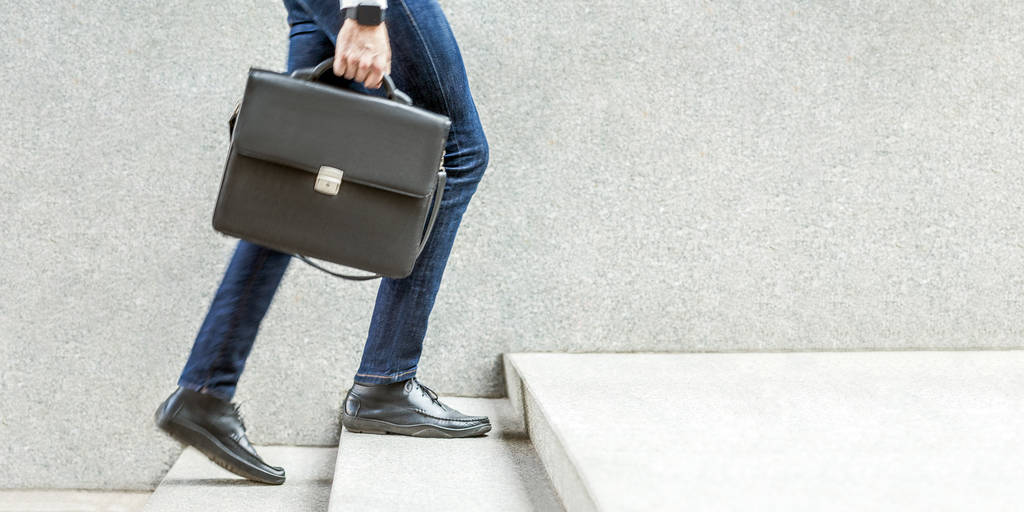 Бізнесмен з чорним портфелем в руці, що йде по сходах, Підвищення і концепція зростання
  - Фото, зображення