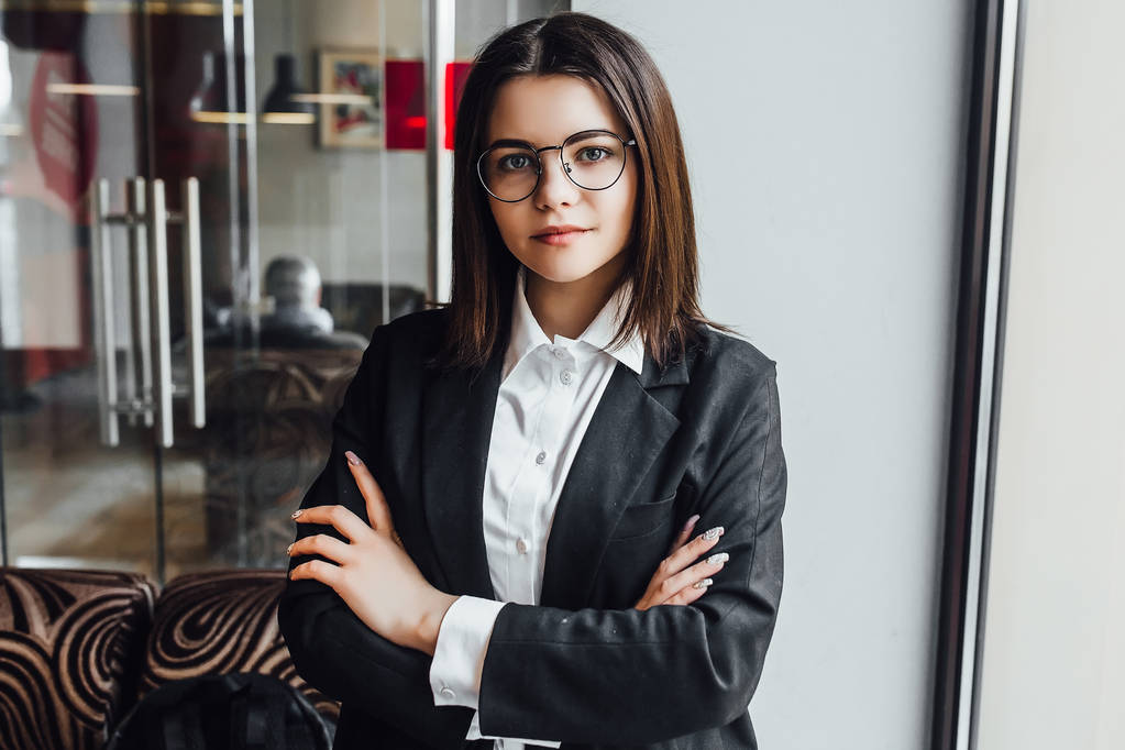 Jovem mulher de negócios bonita em óculos no café, foco em primeiro plano
 - Foto, Imagem