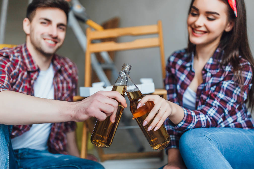 Giovane coppia che beve birra nel nuovo appartamento, focus selettivo
 - Foto, immagini