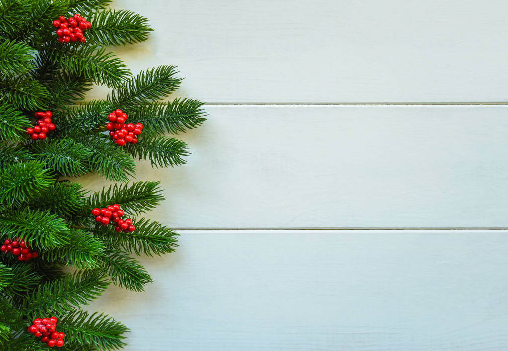Vánoční zázemí pro přání s větvemi vánočních stromku, dekorace a červené kuličky, na dřevěné desce. Pohled shora s prostorem kopírování pro text. - Fotografie, Obrázek