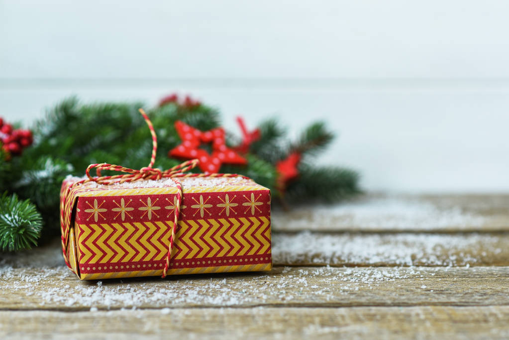 Fond de Noël avec des décorations et une boîte cadeau sur une planche en bois sombre. Cadeau de Noël, étoiles, branches de sapin. Image tonique avec espace de copie
. - Photo, image