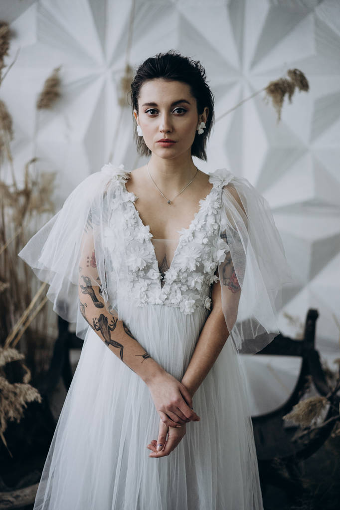 retrato de noiva vestindo vestido branco em estilo boho e olhando para a câmera
  - Foto, Imagem