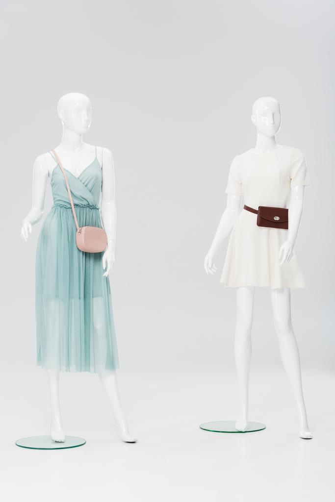пластикові манекени з сумками та сукнями ізольовані на сірому
 - Фото, зображення
