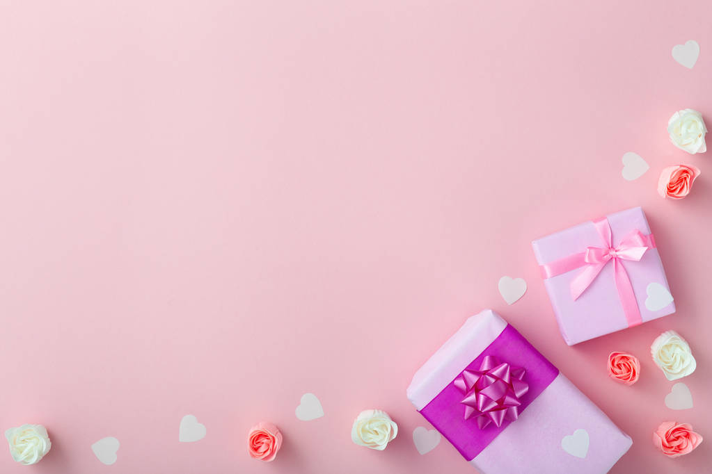 regalos con corazones confeti y rosas, cajas envueltas en papel decorativo sobre fondo rosa pastel, vista superior, concepto de vacaciones
 - Foto, imagen