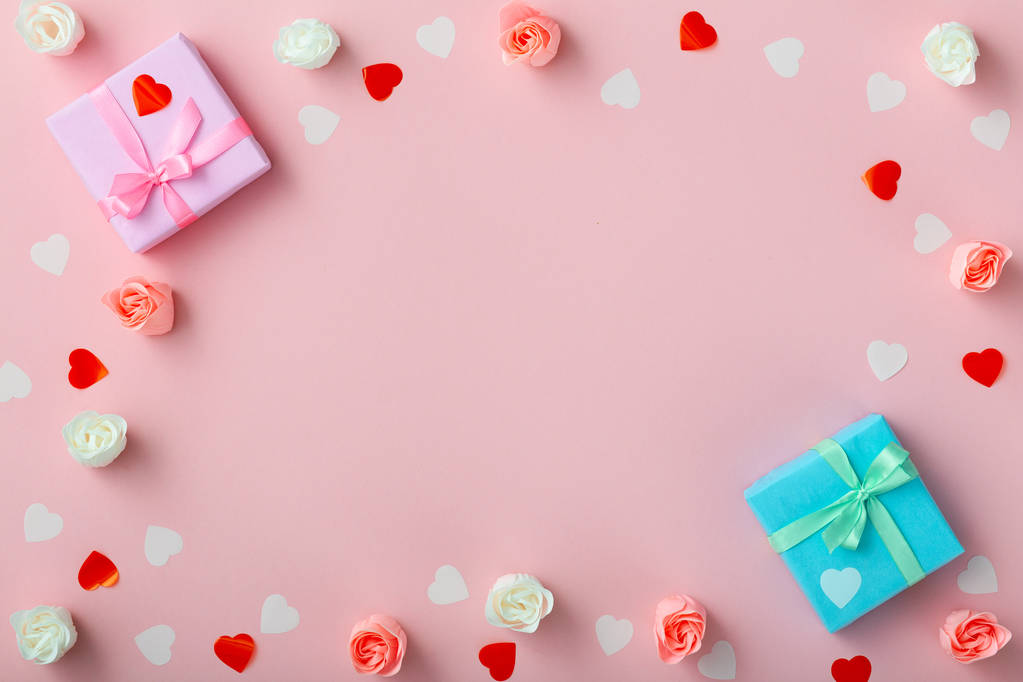 Geschenke mit Konfetti-Herzen und Rosen, Schachteln mit Dekorpapier auf pastellfarbenem rosa Hintergrund, Ansicht von oben, Urlaubskonzept - Foto, Bild