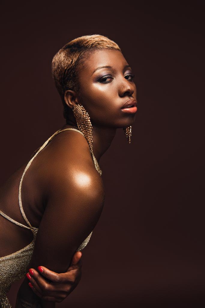 Fashion Shoot met Afro-Amerikaanse vrouw met kort haar geïsoleerd op bruin - Foto, afbeelding