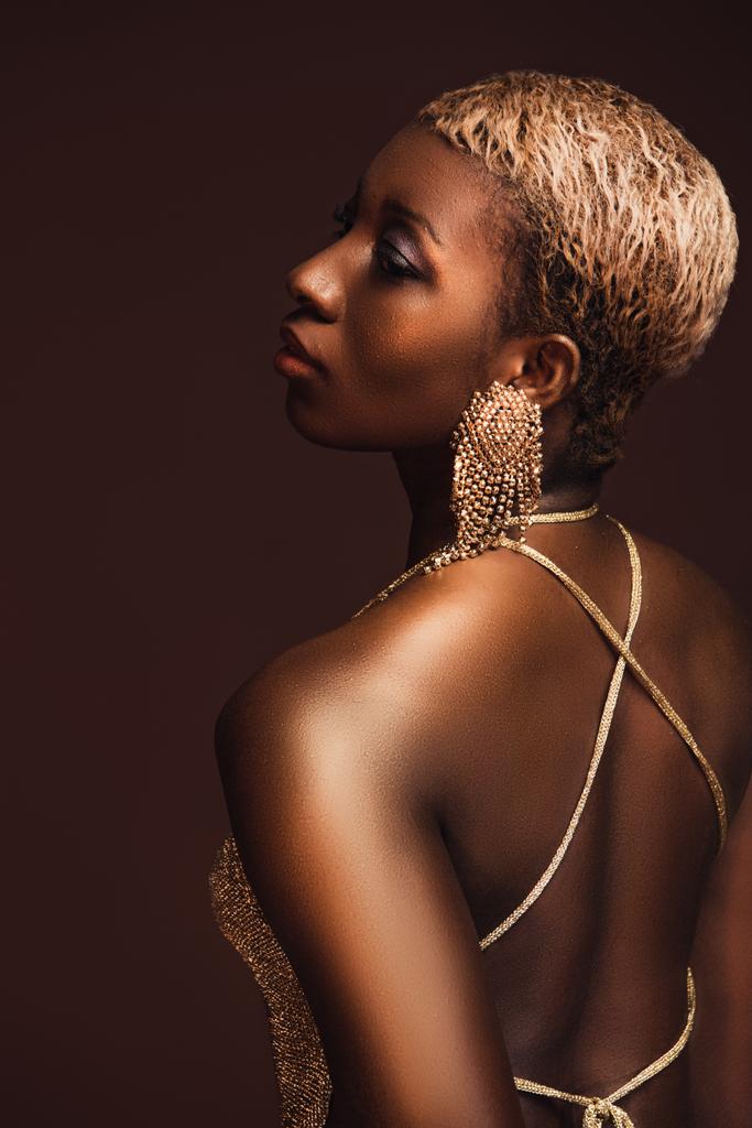 назад вид афроамериканської жінки з коротким волоссям ізольований на коричневий - Фото, зображення