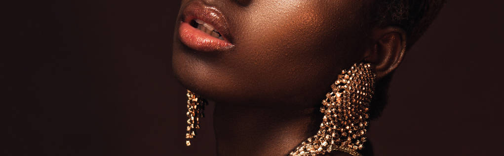 vue recadrée d'une femme afro-américaine souriante avec des boucles d'oreilles isolées sur brun
 - Photo, image
