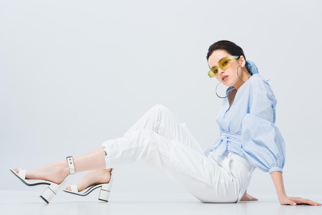 beautiful stylish girl in sunglasses sitting and posing on grey - Photo, Image