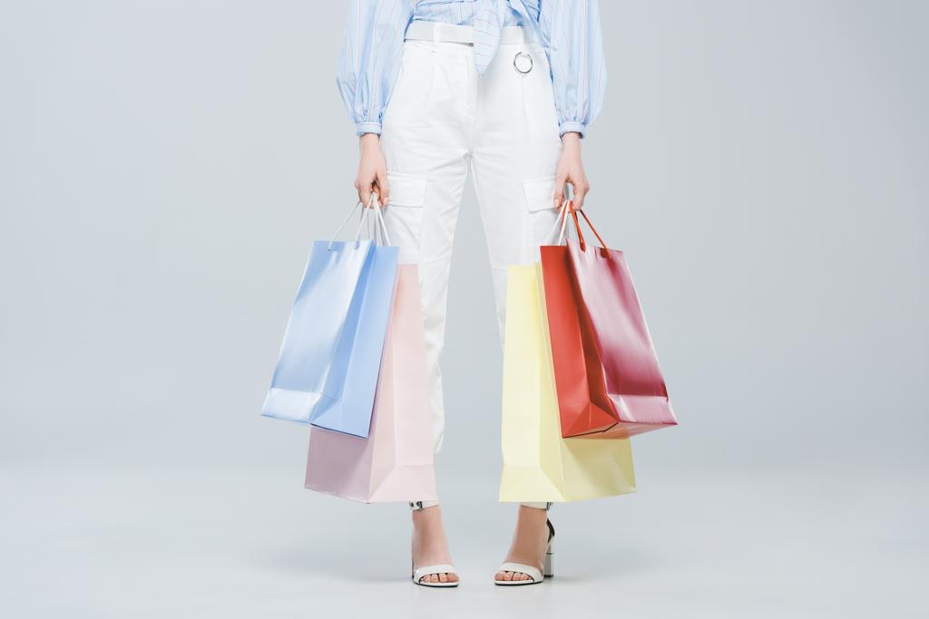 Vue recadrée de fille à la mode avec des sacs à provisions sur gris
 - Photo, image