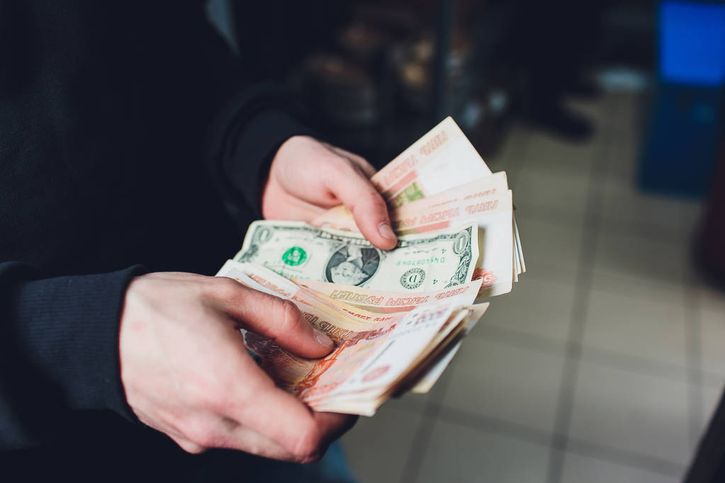 A man holds rubles and dollars in his hand, a businessman holds money in his hand. - Photo, Image
