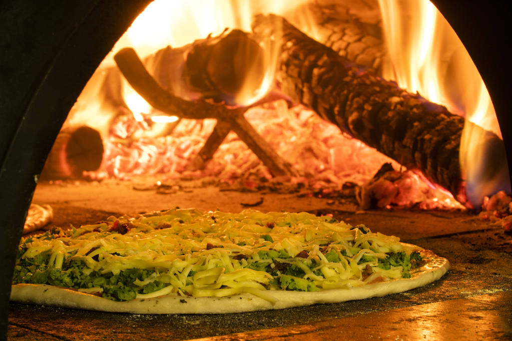 木製オーブン内のイタリアンピザ  - 写真・画像