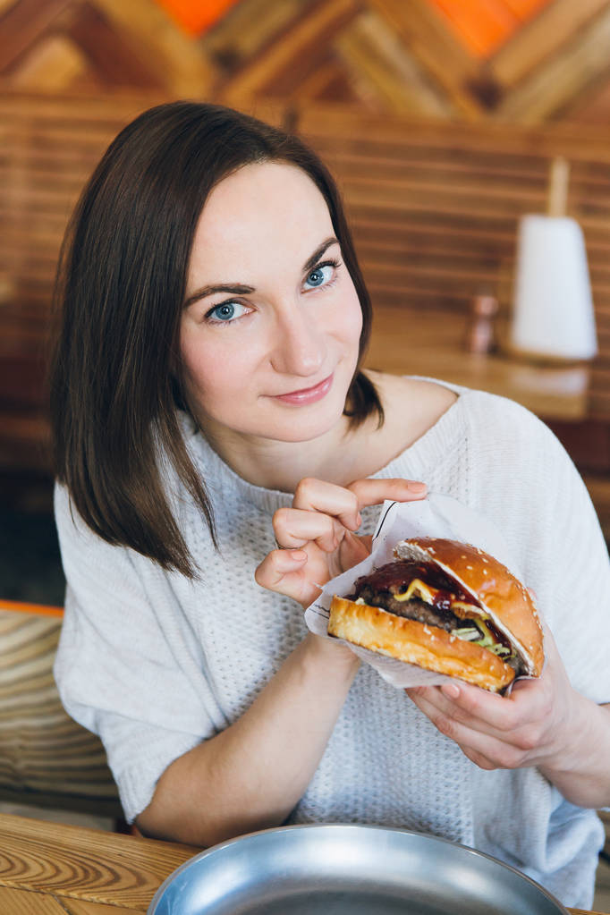 Nő eszik egy frissen elkészített finom Burger  - Fotó, kép
