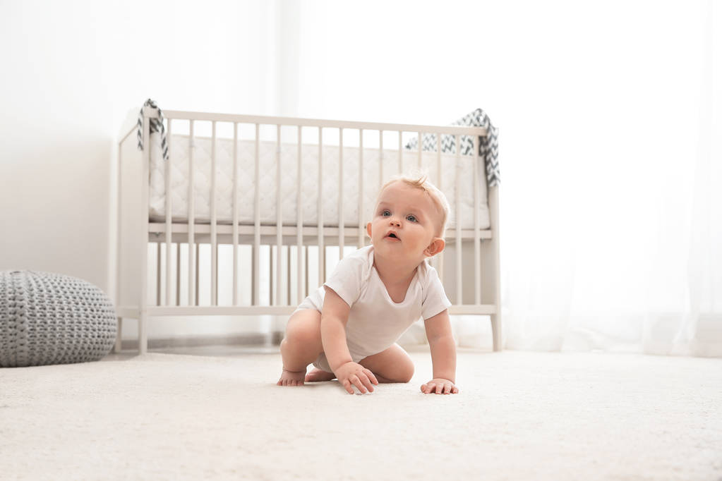Cute little baby crawling on carpet indoors - Photo, Image