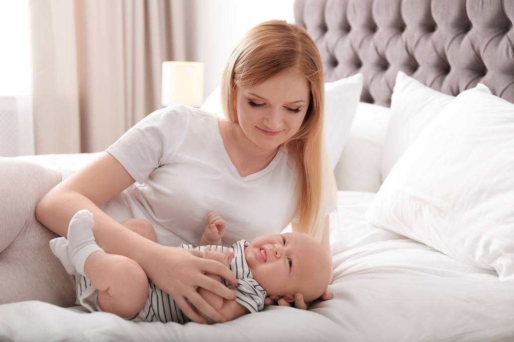 Mother with her baby resting on bed at home - Photo, Image