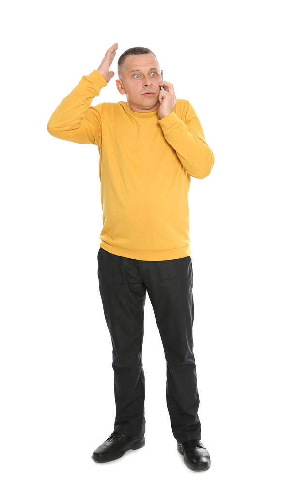 Portrét citového dospívající muže, který mluví v telefonu proti Bílému pozadí - Fotografie, Obrázek