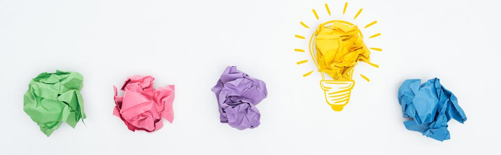 tiro panorâmico de bolas de papel amassadas multicoloridas e ilustração lâmpada no fundo branco, conceito de negócio
 - Foto, Imagem