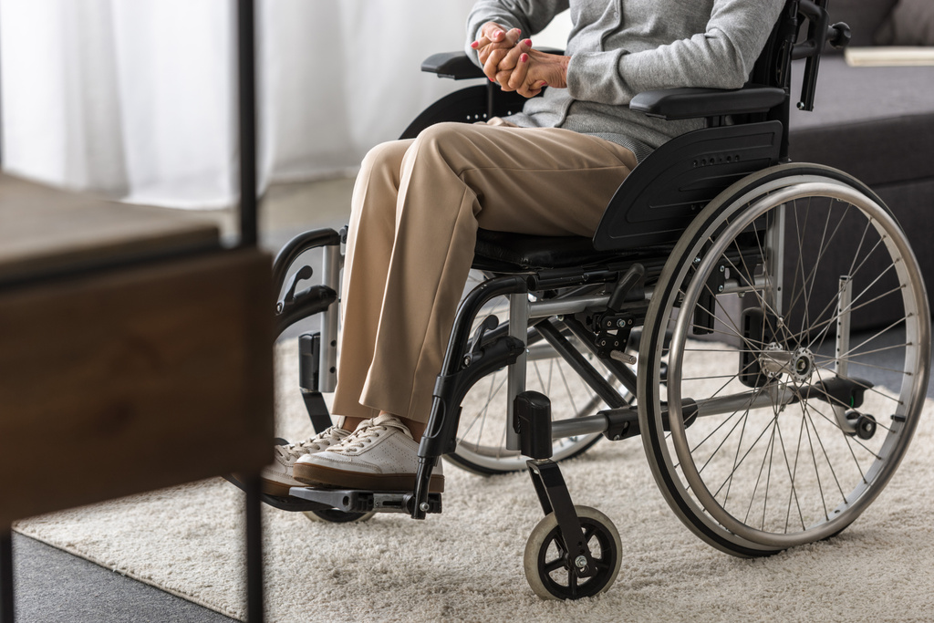 részleges kilátás a fogyatékkal élők Senior nő a kerekesszékkel otthon - Fotó, kép