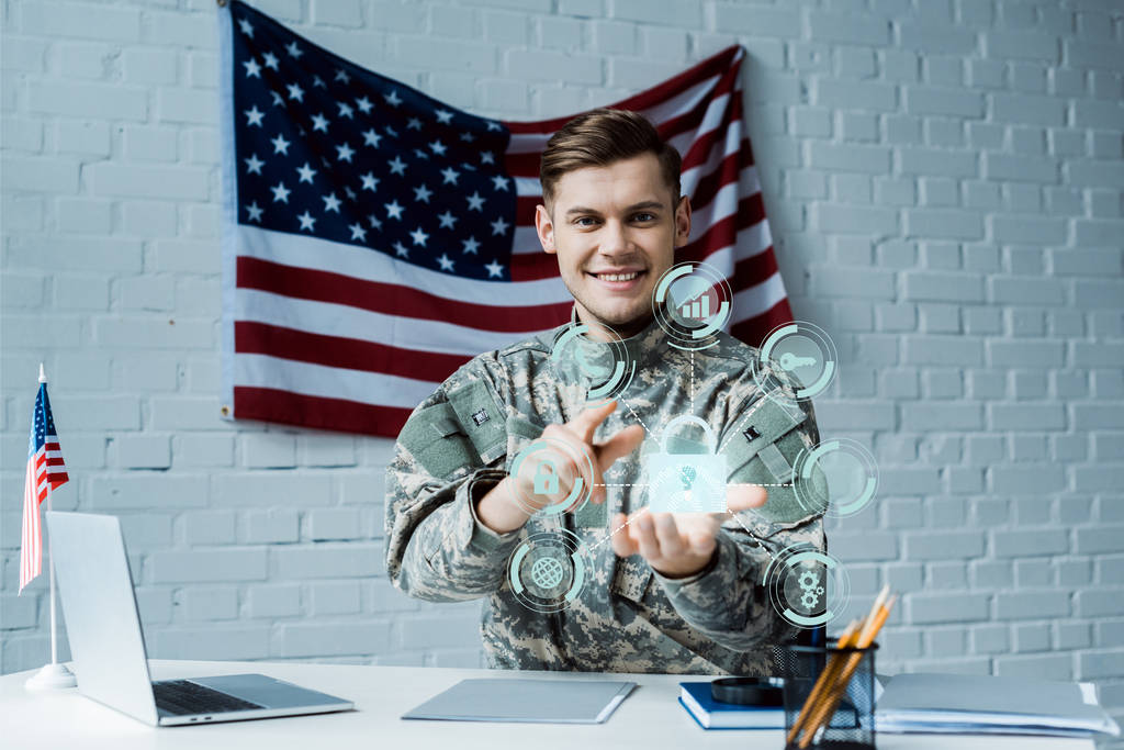 vrolijke man in militair uniform wijzend met vinger op virtueel hangslot in de buurt van laptop  - Foto, afbeelding