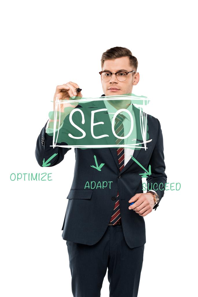 jóképű üzletember a szemüveg gazdaság marker toll mellett SEO betűkkel a fehér  - Fotó, kép