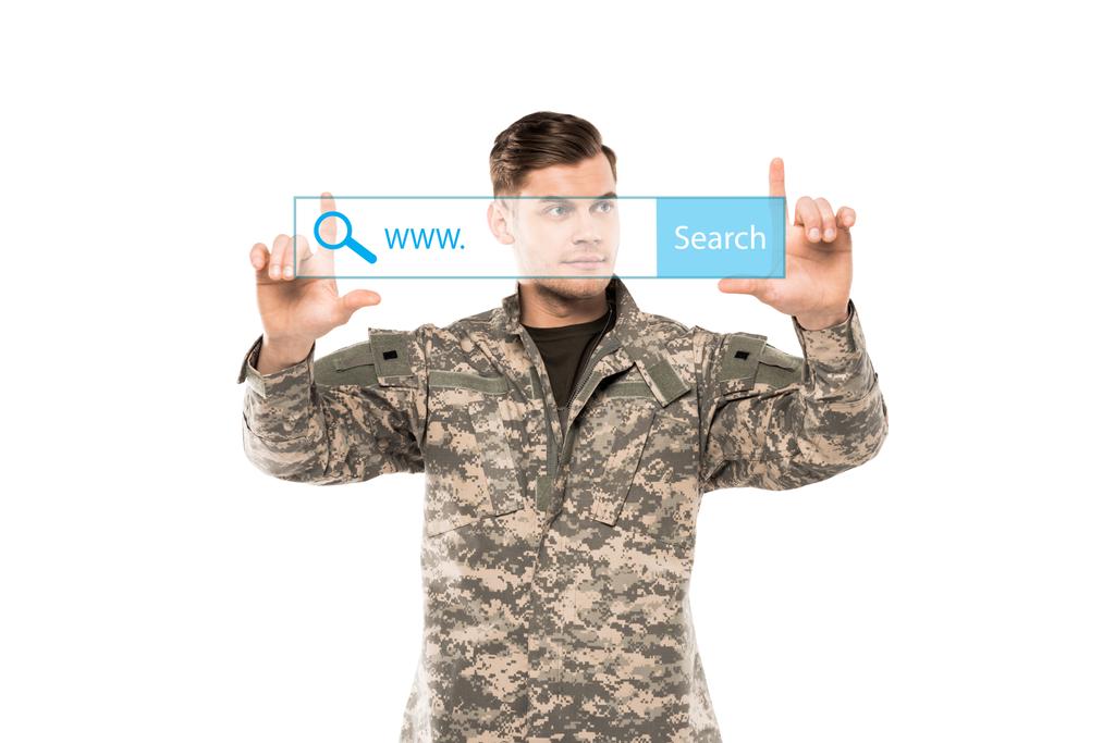 όμορφος άντρας με στρατιωτική στολή που σημαδεύει με τα δάχτυλα στη γραμμή διεύθυνσης στο λευκό  - Φωτογραφία, εικόνα
