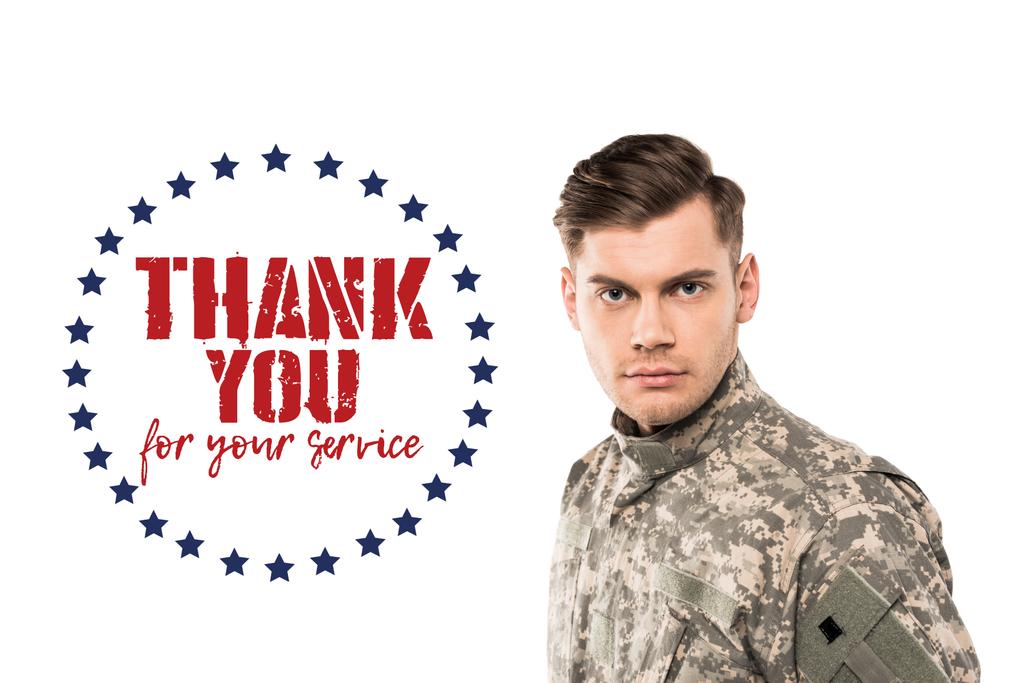 serious and handsome soldier in uniform looking at camera near thank you for your service lettering on white  - Photo, Image