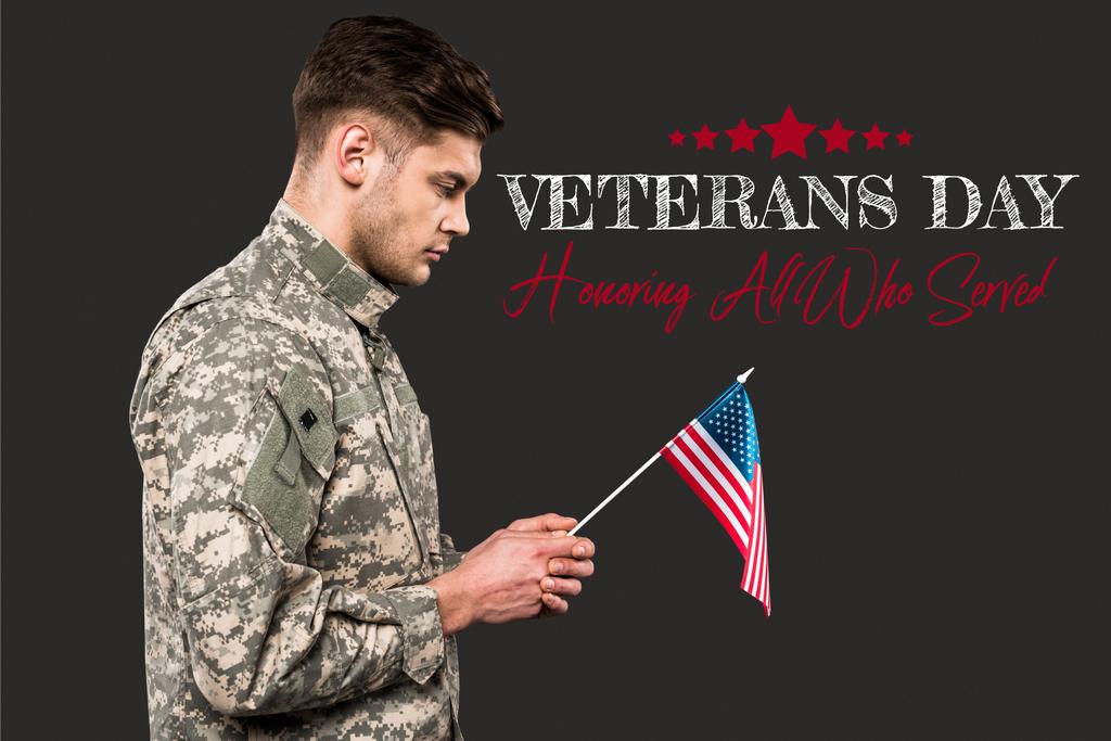 triste uomo in uniforme militare con bandiera americana vicino ai veterani giorno lettering su grigio
  - Foto, immagini