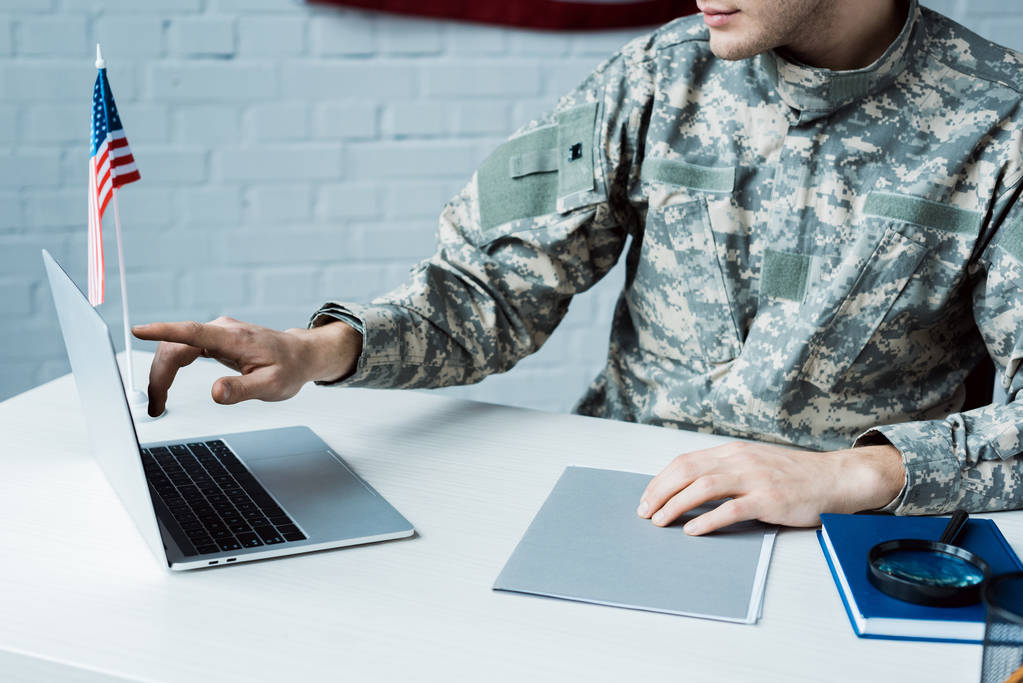 vista recortada del soldado señalando con el dedo a la computadora portátil en la oficina
  - Foto, Imagen