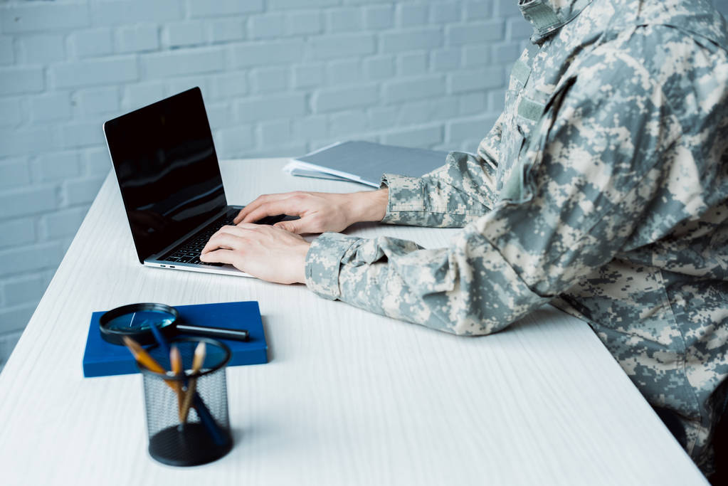 vue recadrée de l'homme militaire à l'aide d'un ordinateur portable avec écran blanc
  - Photo, image