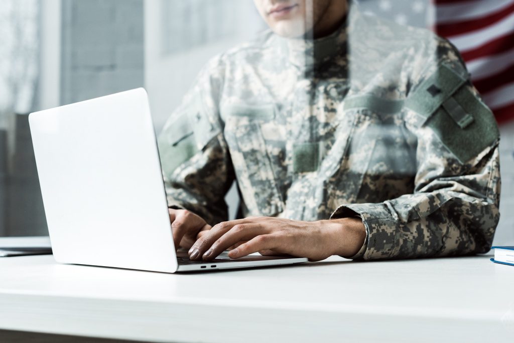 dizüstü bilgisayar kullanarak kamuflaj üniformalı askerin kırpılmış görünümü  - Fotoğraf, Görsel